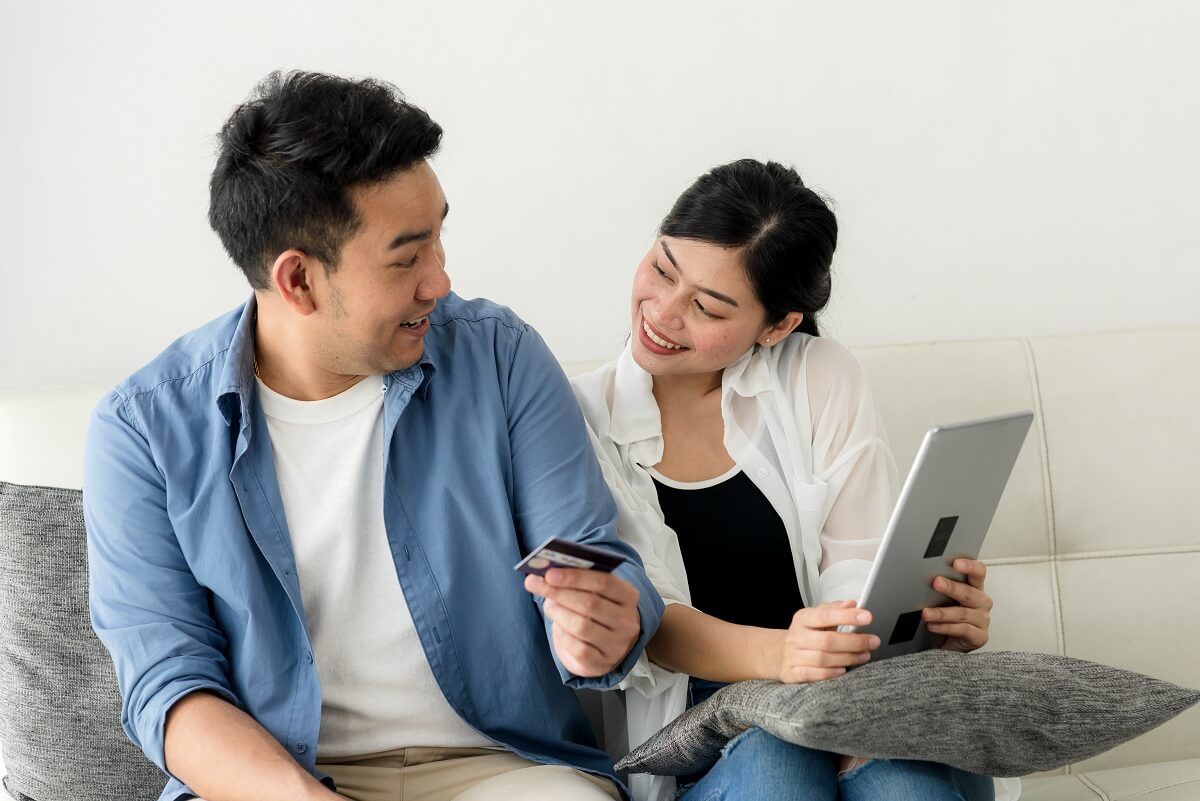 Couple smiling while looking at computer.